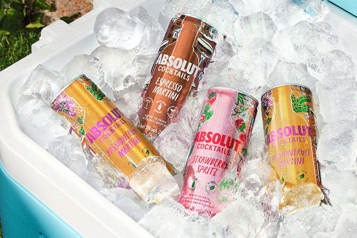 Pernod Ricard's new range of Absolut ready-to-drink cans with one can of Absolut Espresso Martini, Absolut Strawberry Spritz and two cans of Absolut Passionfruit Martini in a cooler full of ice.