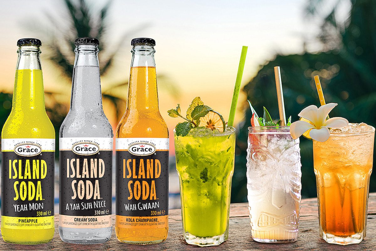 Three bottles of Grace Foods new Island Soda range, from left to right: Pineapple, Cream Soda and Kola Champagne. Next to them are three glasses with the drinks inside.