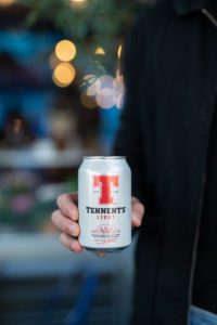 A person stands holding on to a new 330ml can of Tennent's Light.