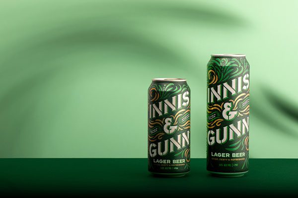 Two cans of Innis & Gunn stand side by side against a green background.