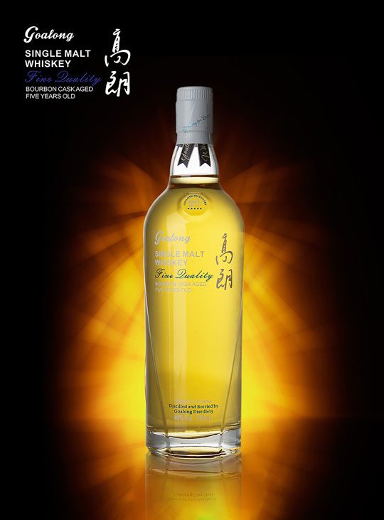 The new Gaolong Single Malt whisky bottle standing against a dark, shadowy background with a yellow light around the bottle.