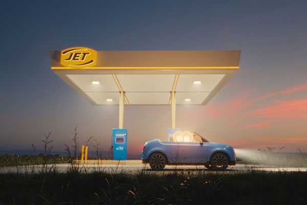 A lit up Jet fuel forecourt station with a blue car sitting under the roofing. Two people with lightbulbs for heads sit in the car ready to drive off.