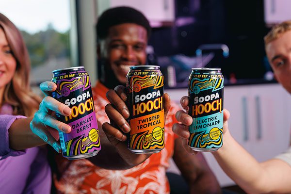 Three people each hold a can of Soopa Hooch (left to right) Soopa Hooch Darkest Berry, Soopa Hooch Twisted Tropical and Soopa Hooch Electric Lemonade.