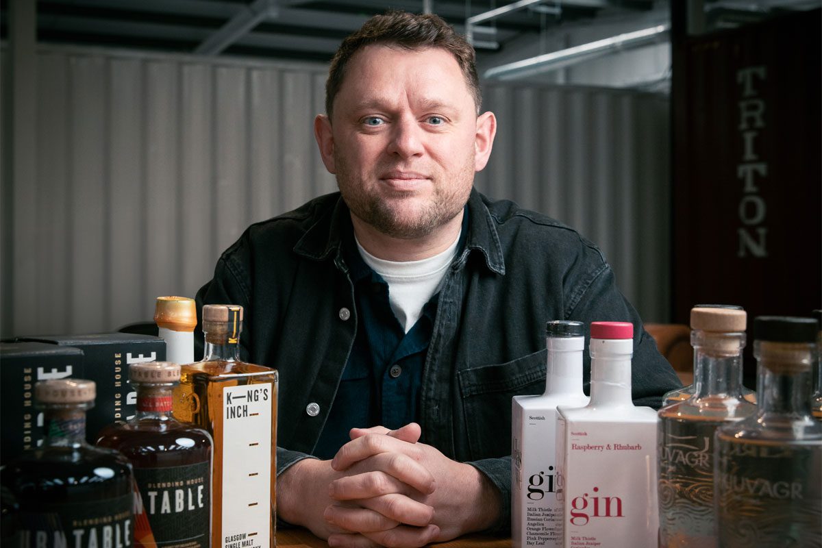 Kilninian founder Jamie Williamson stands behind bottles of spirits including (left to right) Turntable, King's Inch, Glaswegin and Kirkjuvagr Orkney Gin.