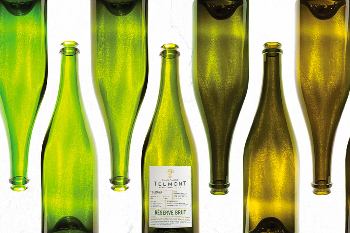 Bottles of green glass showing the transition in colours with a bottle of Telmont Champagne in the middle.