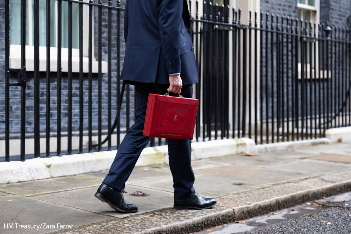 Jeremy Hunt walks carrying the red Budget briefcase towards 10 Downing Street.