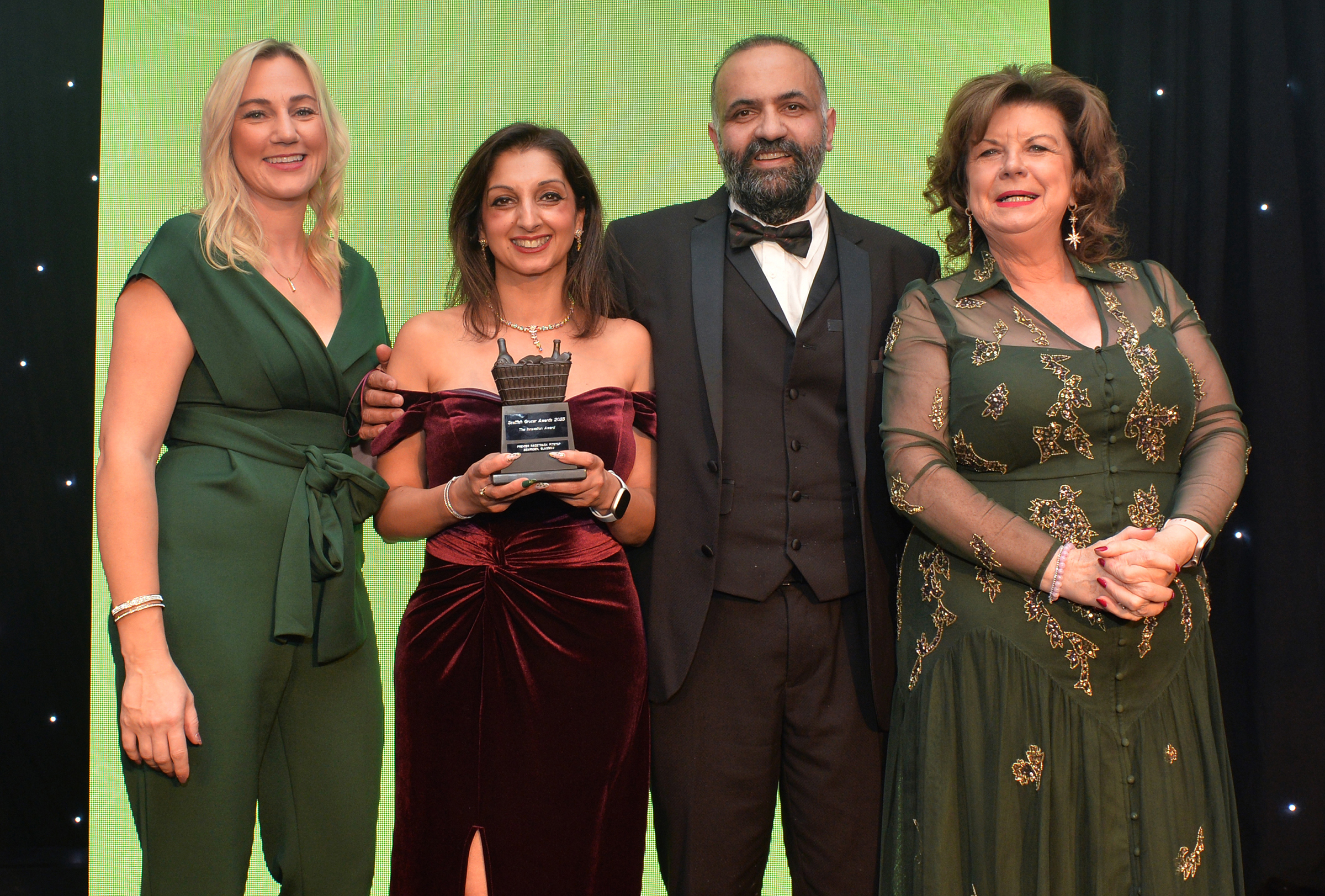 Shamly and Vikas Sud, whose GHSL Ltd business owns Premier RaceTrack Pitstop Bearsden, are congratulated by Laura McDermaid, of Philip Morris, and Scottish Grocer Awards host Elaine C Smith.