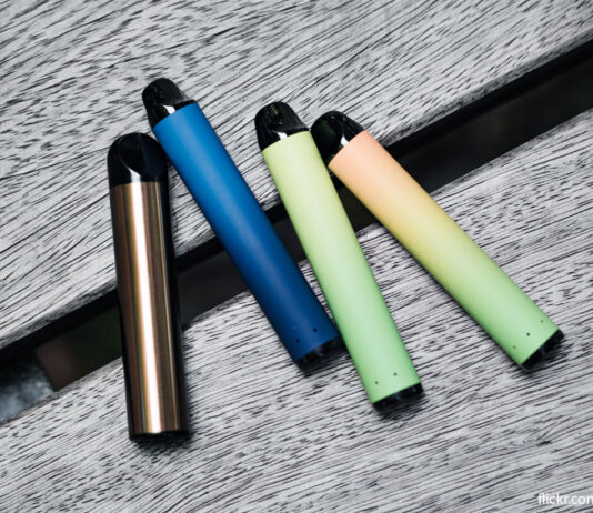 ACS warns vape ban will fuel illicit market Disposable vape devices sit on a wooden bench in an array of colours.