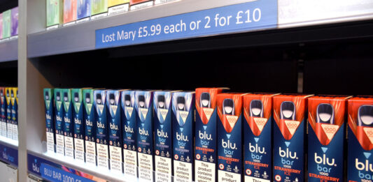 Time to act on Tobacco & Vapes Bill says Imperial Brands A row of Blu Bar disposable vapes in a gantry.