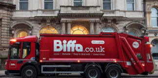 A Biffa branded waste disposal truck is parked outside of a building.
