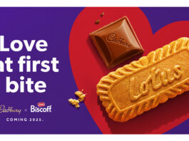 Cadbury announces new partnership with Lotus Biscoff Promotional image for the team up of Cadbury and Lotus Bakeries with a piece of Cadbury Dairy Milk chocolate and a Lotus biscuit side by side in a red love heart with text on the left reading 'Love at first bite'.