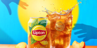 A can of Lipton Iced Tea sits next to a glass filled with the drink with peach pieces around them. There is also a blue background with yellow sun and silhouetted hands reaching for the drink.