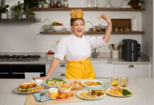 Social media influencer Poppy O'Toole stands wearing a crown made of chips in front of food dishes containing McCain's Air Fryer range.