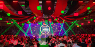 A large venue hall hosting the Spar Scotland 2023 Awards ceremony with rows of people seated at tables with red and green lighting.