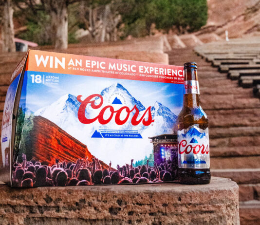 Win a trip to Colorado with new Coors promo A pack of Coors lager sits on a rock step with a bottle of Coors lager to its side with red rock steps in the background.