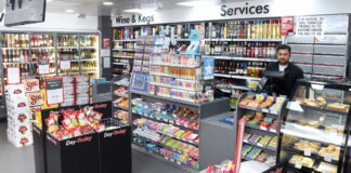 A Day-Today store floor with the counter area, product bins close to the checkout and a staff member behind the till.