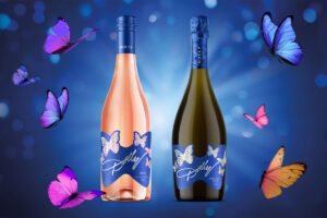 Pack shots of the Dolly Parton Dolly Wines range including the Rose and Prosecco variants against a blue background with butterflies around the bottles.