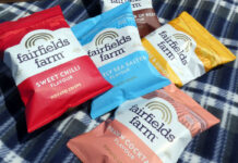 Lifestyle image of packs of Fairfields Farm crisps lying on top of checked blanket.