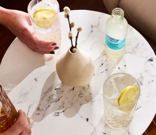Franklin & Sons adapts to changing tastes Drinks sit on a white marble table with a bottle of Franklin & Sons Sicillian Lemon on the table next to a vase.