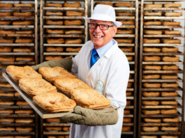 Macallan acquires Malcolm Allan and Macsween Gordon Allan holds a tray of steak pies with trays stacked up behind him.