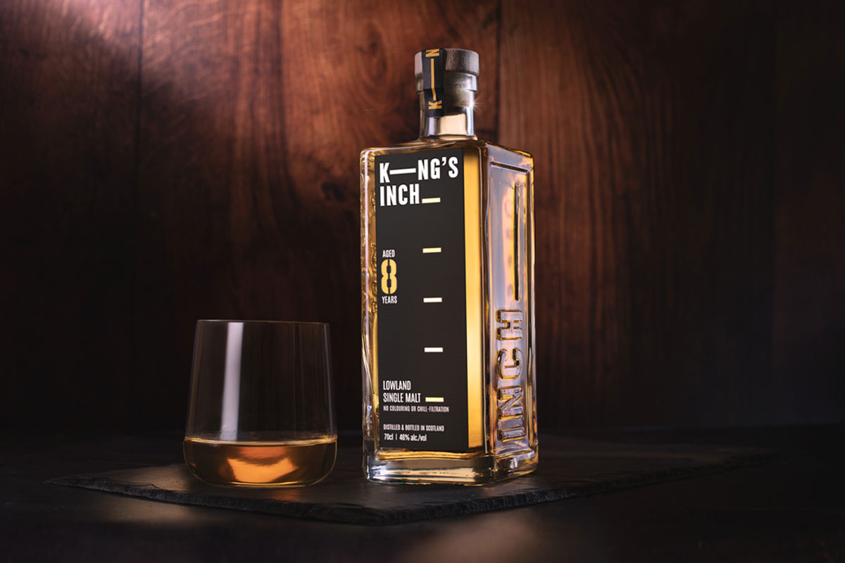 Promotional image of King's Inch 8 Year Old expression featuring a bottle of the whisky with a glass next to it containing the dram.