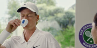 Jannik Sinner drinks from a Lavazza branded espresso cup with the Wimbledon logo behind him and the Lavazza logo in the bottom right corner.