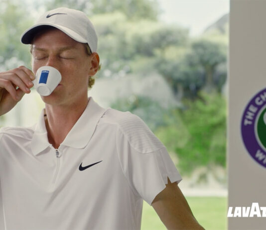 Lavazza takes to centre court in Wimbledon campaign Jannik Sinner drinks from a Lavazza branded espresso cup with the Wimbledon logo behind him and the Lavazza logo in the bottom right corner.
