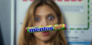 A pack of Mentos Discovery floats in front of a woman's face who is interested in the sweet.