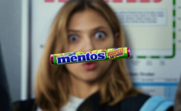 A pack of Mentos Discovery floats in front of a woman's face who is interested in the sweet.