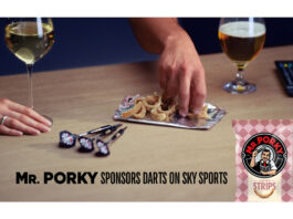 Tayto Group hits a bullseye in darts sponsorship on Sky Sports People pick from an open pack of Mr Porky pork scratchings with darts on the table and drinks around their hands, text reads "Mr. Porky sponsors Darts on Sky Sports".