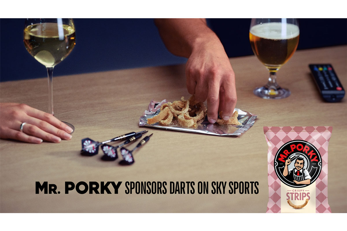 People pick from an open pack of Mr Porky pork scratchings with darts on the table and drinks around their hands, text reads "Mr. Porky sponsors Darts on Sky Sports".