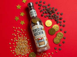 Popcorn Kitchen pops in the home for Christmas A pack shot of Popcorn Kitchen Chocolate Treasure sits against a red background with popcorn kernels and chocolate pieces and coins around it.