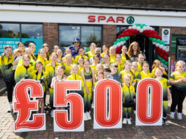 Spar Scotland dances into the summer A group of people stand in front of Spar Garthamlock holding a £500 sign wearing yellow shirts.