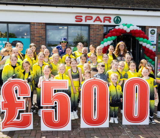 Spar Scotland dances into the summer A group of people stand in front of Spar Garthamlock holding a £500 sign wearing yellow shirts.