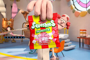 Still from Swizzels TV ad where a man holds up a bag of Swizzels Drumstick Squashies.