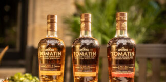 Bottles from the Tomatin Sherry Cask Collection are lined up on a table together including The Manzanilla Edition, The Palo Cortado Edition and the Pedro Ximénez Edition.