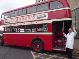 Tunnock’s drives support for local charity Sir Boyd Tunnock stands next to a vintage double decker bus with a Tunnock's Caramel Wafer advert on its side.