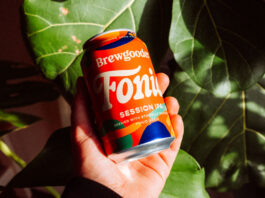 A Fairtrade brew to do good from Brewgooder A person holds a can of Brewgooder Fairtrade Fonio grain beer in front of green leaves.