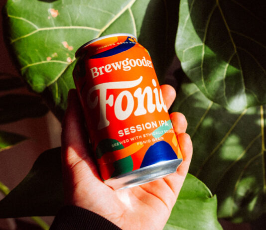 A Fairtrade brew to do good from Brewgooder A person holds a can of Brewgooder Fairtrade Fonio grain beer in front of green leaves.
