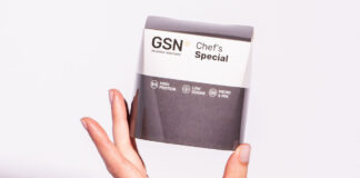 A person holds a pack of GSN Chef's Special frozen chicken meal.