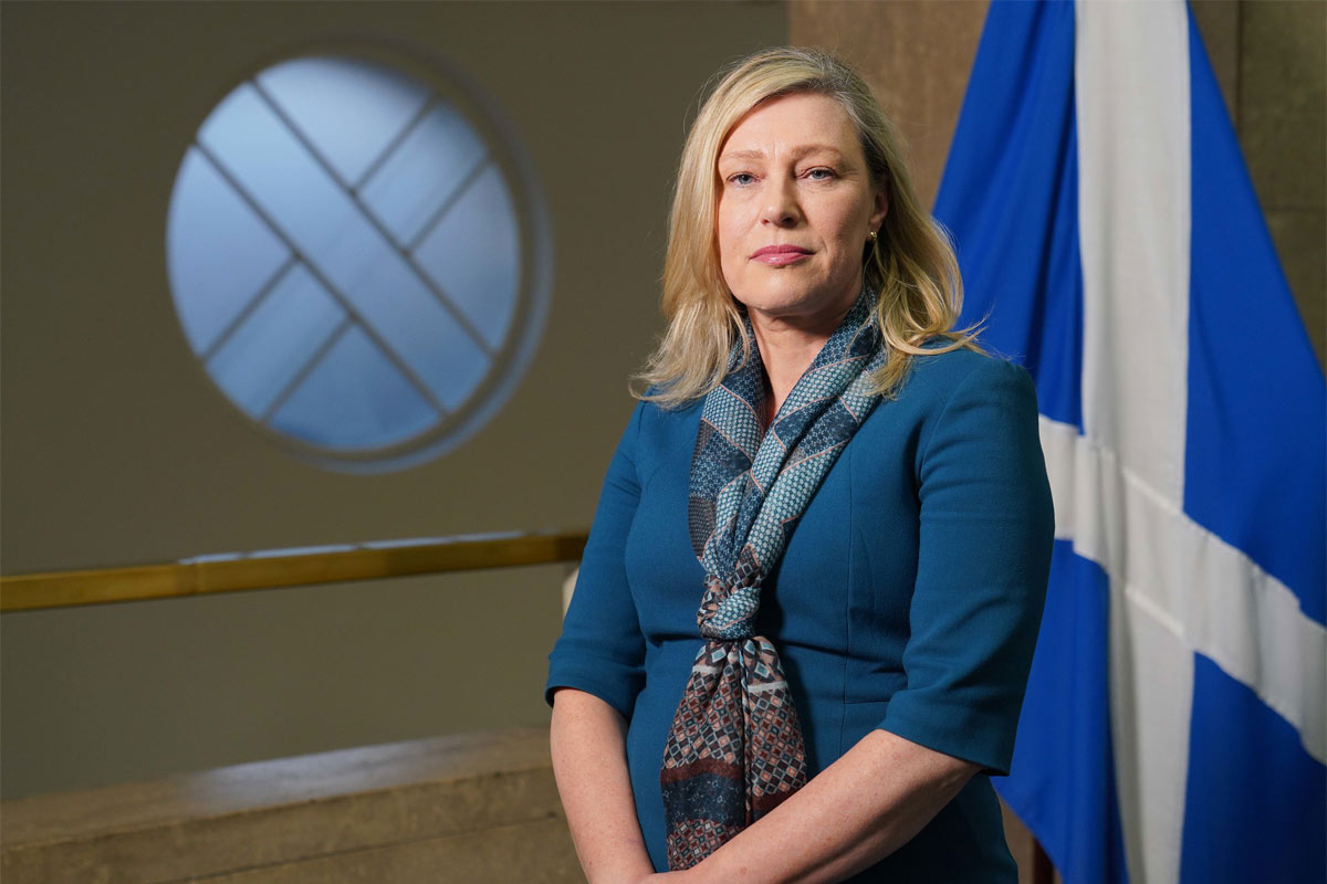 Gillian Martin, acting net zero secretary, stands in Scottish Parliament with the Scotland flag behind her. 