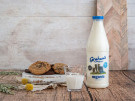 Graham’s bags Great Taste Awards A bottle of Graham's whole milk stands next to a plate with chocolate chip cookies on it.