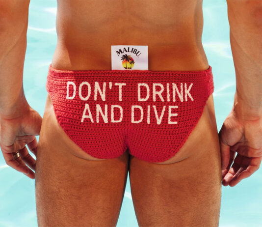Tom Daley dives into responsible drinking campaign with Malibu Olympic diver Tom Daley stands in front of a pool in diving clothing with a Malibu branded tag sticking out the clothes with the text reading 'Don't Drink and Dive'.