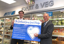 Jamie Buchanan, SGF’s Go Local programme director, right, and colleague Aidan Smith signing the Scotland Loves Local Pledge.