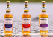 Bottles of Tomintoul whisky stand in water.