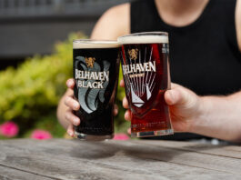 Belhaven serves a double win Two people sit holding Belhaven branded glasses with beer inside them and clink them together.