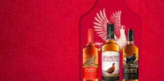 Bottles of The Famous Grouse range lined up against a red background with the illustration of a grouse behind the bottles.