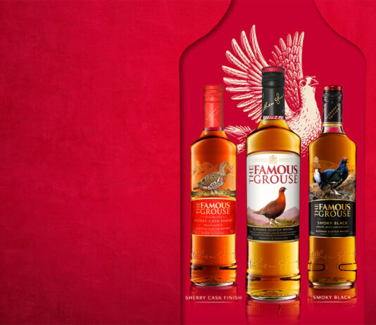 The Famous Grouse moves to William Grant & Sons Bottles of The Famous Grouse range lined up against a red background with the illustration of a grouse behind the bottles.