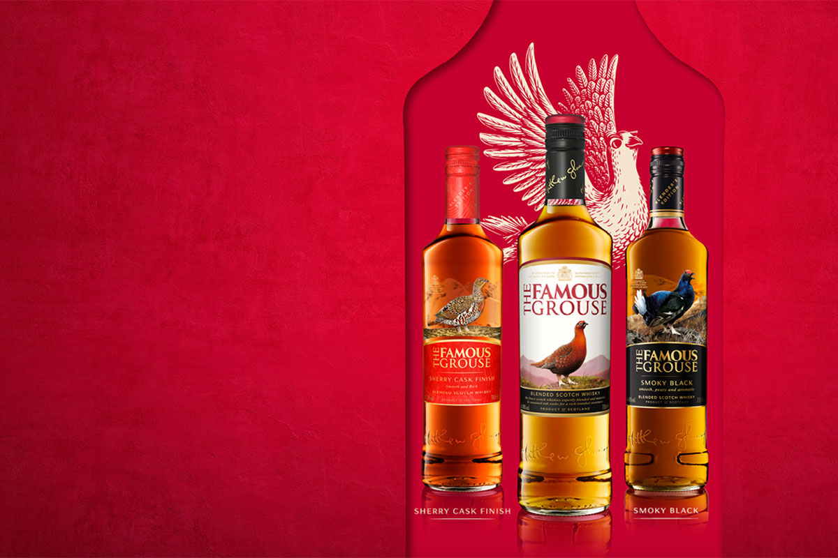 Bottles of The Famous Grouse range lined up against a red background with the illustration of a grouse behind the bottles.