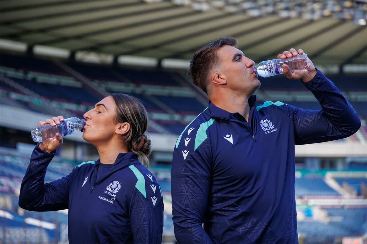 Rugby Union players Emma Wassell and Sam Skinner both drink from Highland Spring bottles in the middle of Murrayfield Stadium.